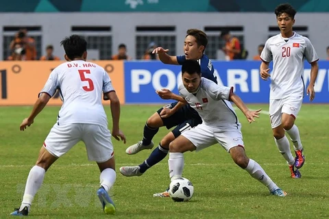 Pha tranh bóng quyết liệt giữa cầu thủ Phạm Đức Huy (thứ 2, phải) của Olympic Việt Nam và Kouta Wanabe (giữa, phía sau) của Olympic Nhật Bản trong trận đấu ở bảng D, ASIAD 2018 ở Cikarang, Indonesia ngày 19/8. (Ảnh: AFP/TTXVN)