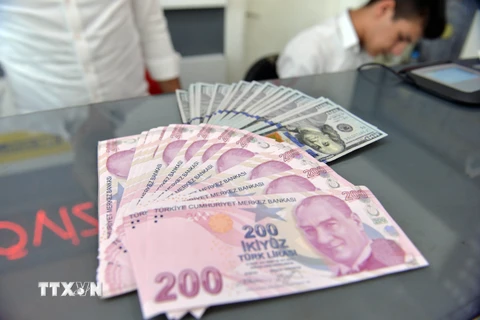 Đồng Lira của Thổ Nhĩ Kỳ và đồng USD tại một cửa hàng đổi tiền ở Ankara. (Ảnh: THX/TTXVN)