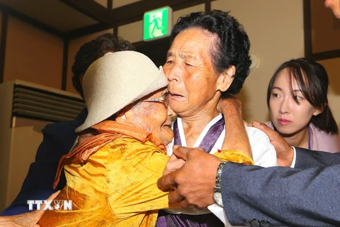 Cụ Kang Jung-ok (trái), 100 tuổi, sống ở Hàn Quốc gặp lại em gái Kang Jong Hwa (giữa), 85 tuổi, sống ở Triều Tiên tại cuộc đoàn tụ gia đình ly tán ở núi Kumgang ngày 24/8. (Ảnh: AFP/TTXVN)