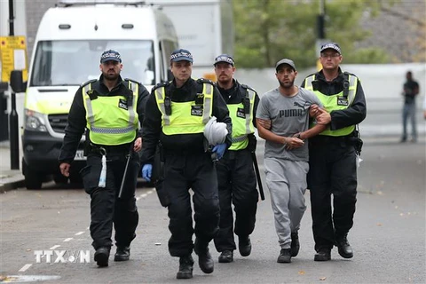 Cảnh sát bắt giữ một đối tượng tình nghi tiếp tay cho khủng bố trong cuộc tuần tra tại London ngày 27/8. (Ảnh: AFP/TTXVN)