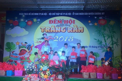 Đại diện Ủy ban Nhân dân xã Nam Phương Tiến tặng quà động viên các em nhỏ khuyết tật. (Ảnh: Nguyễn Cúc/TTXVN) 