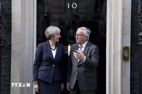 Thủ tướng Anh Theresa May (trái) trong cuộc gặp Chủ tịch Ủy ban châu Âu Jean-Claude Juncker (phải) tại London ngày 26/4/2017. (Ảnh: AFP/TTXVN)