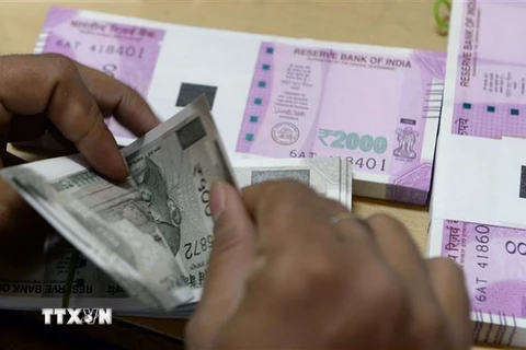 Kiểm đồng rupee tại một ngân hàng ở Mumbai, Ấn Độ. (Ảnh: AFP/TTXVN)