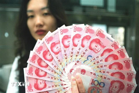 Nhân viên ngân hàng kiểm tiền giấy mệnh giá 100 Nhân dân tệ mới của Trung Quốc. (Ảnh: AFP/TTXVN)