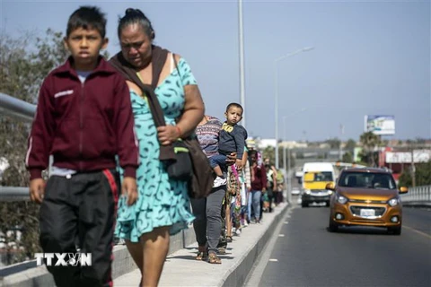 Người di cư tiến về khu vực biên giới Mexico-Mỹ tại bang Baja California (Mexico). (Ảnh: AFP/TTXVN)
