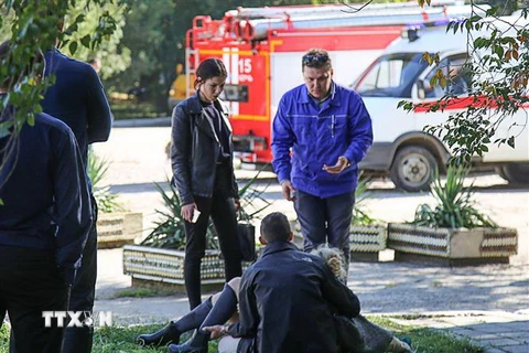Lực lượng cứu hộ hỗ trợ một nạn nhân bị thương trong vụ tấn công tại Trường cao đẳng khu vực Kerch trên bán đảo Crimea ngày 17/10/2018. (Ảnh: AFP/TTXVN)