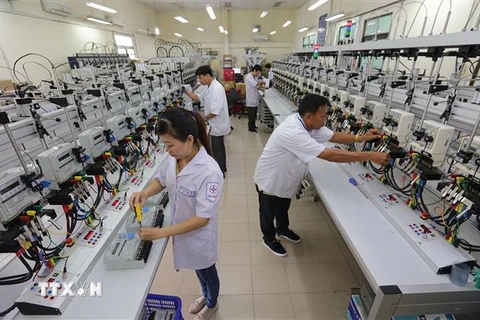 Đội ngũ kỹ sư Công ty Thí nghiệm điện lực (Tổng Công ty Điện Lực Thành phố Hồ Chí Minh) nghiên cứu sản xuất đồng hồ điện 3 pha. (Ảnh: Thanh Vũ/TTXVN)