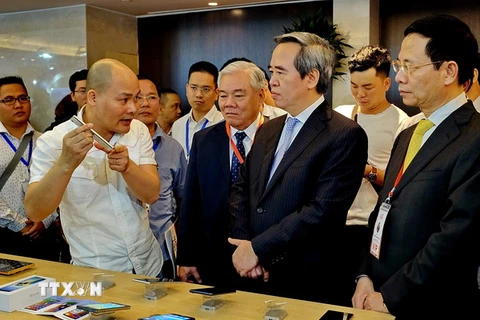 Ông Nguyễn Văn Bình, Ủy viên Bộ Chính trị, Bí thư Trung ương Đảng, Trưởng Ban Kinh tế Trung ương và các đại biểu thăm quan triển lãm quốc tế Smart IoT. (Ảnh: Thế Anh/TTXVN)