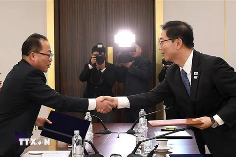 Trưởng đoàn đàm phán Hàn Quốc Chun Hae-sung (phải) và người đồng cấp Triều Tiên Jon Jong-su trao đổi văn kiện chung tại cuộc đàm phán cấp chuyên viên ở làng đình chiến Panmunjom ngày 17/1/2018. (Ảnh: AFP/TTXVN)