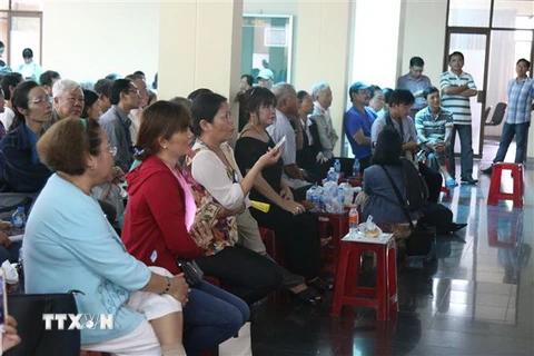 Nhiều người dân theo dõi buổi tiếp xúc tiếp đại diện các hộ dân nằm trong ranh quy hoạch Khu đô thị mới Thủ Thiêm, quận 2 qua màn hình ngày 7/11. (Ảnh: Trần Xuân Tình/TTXVN)