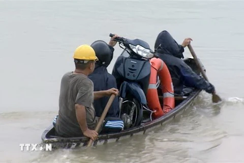 Người dân Phú Yên phải di chuyển bằng thuyền qua vùng ngập nước. (Ảnh: Thế Lập/TTXVN)