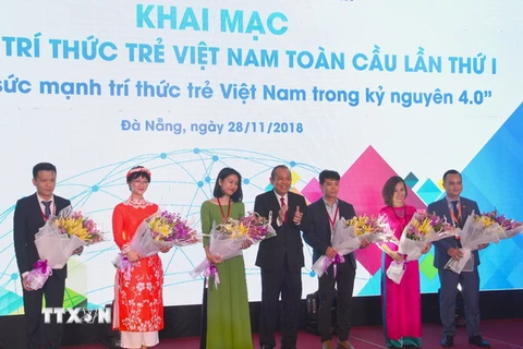 Phó Thủ tướng Thường trực Chính phủ Trương Hòa Bình tặng hoa cho các trí thức trẻ. (Ảnh: Đinh Văn Nhiều/TTXVN)