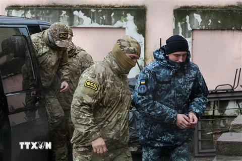 Nhân viên mật vụ thuộc Cơ quan An ninh Liên bang Nga áp giải một thủy thủ Ukraine (phải) bị bắt tới tòa án ở Simferopol, Bán đảo Crimea ngày 27/11/2018. (Ảnh: AFP/TTXVN)