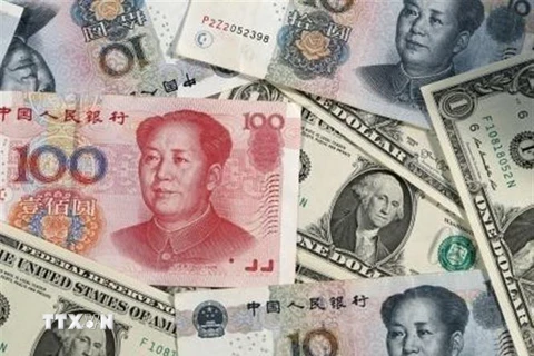 Đồng nhân dân tệ (phía trên) của Trung Quốc và đồng USD. (Ảnh: Kyodo/TTXVN)
