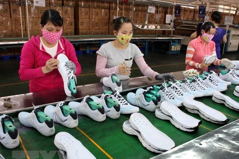 Công nhân làm việc tại dây chuyền sản xuất giày. (Ảnh: Trần Lê Lâm/TTXVN)