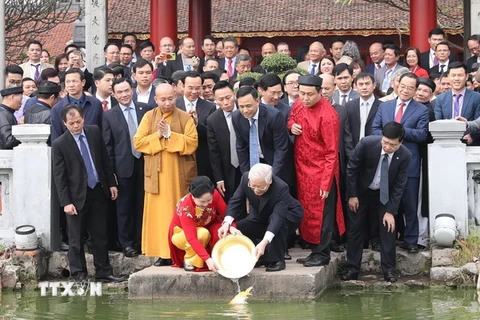 Tổng Bí thư, Chủ tịch nước Nguyễn Phú Trọng và Phu nhân thả cá chép tại hồ Hoàn Kiếm. (Ảnh: Trí Dũng/TTXVN)