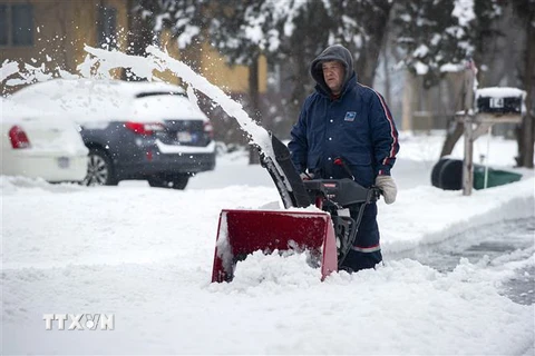 Người dân dọn tuyết trên đường phố tại Saugus, Massachusetts, Mỹ. (Ảnh: AFP/TTXVN)
