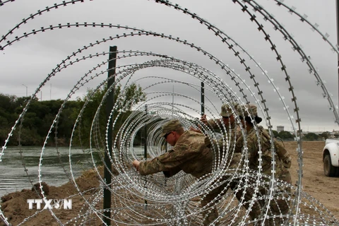 Binh sỹ Mỹ dựng hàng rào an ninh tại khu vực biên giới với Mexico ở Laredo, bang Texas (Mỹ). (Ảnh: AFP/TTXVN)