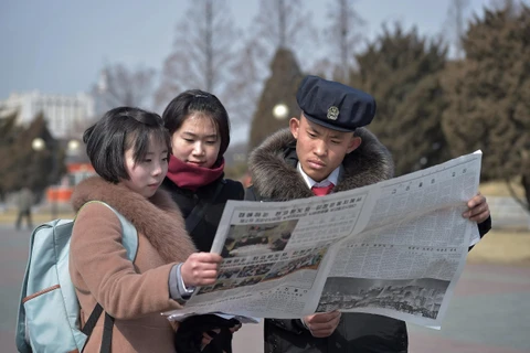 Người dân Triều Tiên theo dõi hình ảnh Chủ tịch Kim Jong-un dự Hội nghị thượng đỉnh Mỹ-Triều lần hai được đăng tải trên báo Rodong Sinmun, cơ quan ngôn luận của Đảng Lao động Triều Tiên, tại thủ đô Bình Nhưỡng, ngày 27/2/2019. (Ảnh: AFP/TTXVN)