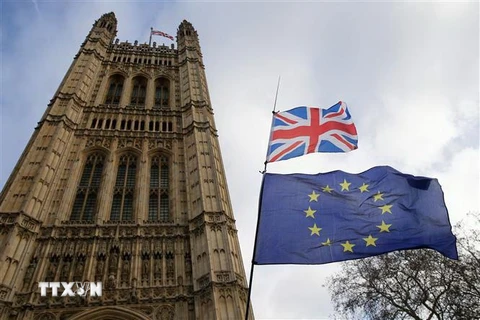 Cờ Anh (phía trên) và cờ EU (phía dưới) bên ngoài tòa nhà Quốc hội ở London, Anh. (Ảnh: THX/TTXVN)