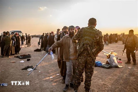 Các tay súng Tổ chức nhà nước Hồi giáo (IS) tự xưng đầu hàng Lực lượng Dân chủ Syria do Mỹ hậu thuẫn tại dinh lũy cuối cùng ở Baghouz, tỉnh Deir Ezzor, miền Đông Syria ngày 22/2/2019. (Ảnh: AFP/TTXVN)
