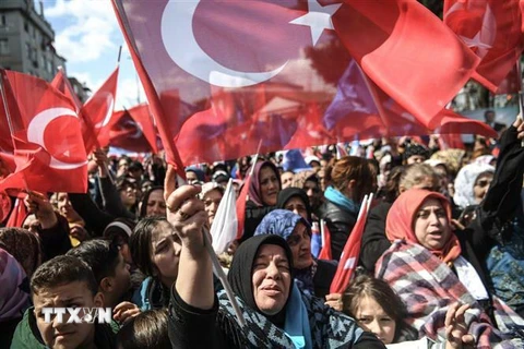 Những người ủng hộ Tổng thống Tayyip Erdogan vẫy quốc kỳ trong chiến dịch vận động tranh cử ở Istanbul, Thổ Nhĩ Kỳ ,ngày 30/3. (Ảnh: AFP/TTXVN)