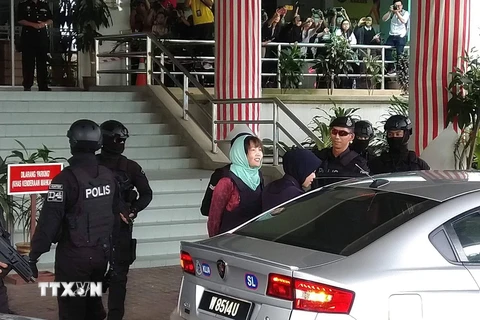 Cảnh sát dẫn giải Đoàn Thị Hương ra xe ôtô sau phiên tòa. (Ảnh: Hà Ngọc/TTXVN)