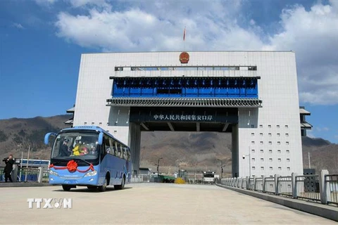 Xe buýt du lịch đi qua cửa khẩu mới khai trương nối thành phố Cát An của Trung Quốc với Manpo của Triều Tiên, ngày 8/4/2019. (Ảnh: AFP/TTXVN)