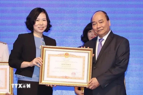 Thủ tướng Nguyễn Xuân Phúc trao tặng Bằng khen của Thủ tướng Chính phủ cho Thông tấn xã Việt Nam vì thành tích xuất sắc tại WEF ASEAN 2018. (Ảnh: Thống Nhất/TTXVN)