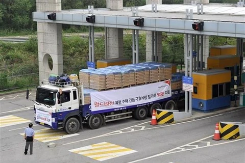 Xe tải Hàn Quốc chở bột mì viện trợ cho các nạn nhân lũ lụt tại Triều Tiên qua cửa khẩu thành phố biên giới Paju, phía bắc Seoul tháng 9/2011. (Ảnh: AFP/TTXVN)