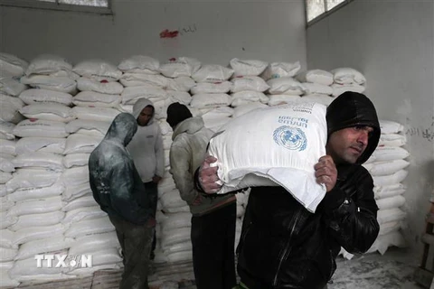 Người tị nạn Palestine nhận lương thực cứu trợ tại Khan Yunis, Dải Gaza. (Ảnh: AFP/TTXVN)