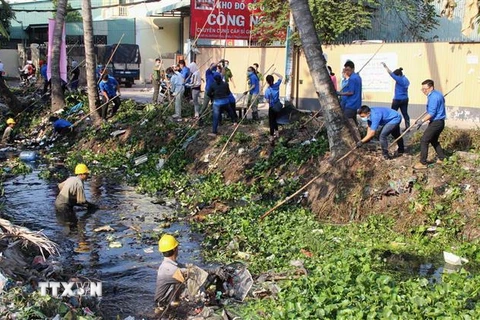 Các lực lượng dọn dẹp vệ sinh môi trường trên rạch Đất Sét, Thành phố Hồ Chí Minh. (Ảnh: Xuân Dự/TTXVN)