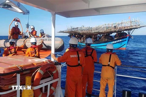 Tàu cứu hộ tiếp cận tàu cá để cấp cứu nạn nhân trên biển. (Ảnh minh họa. TTXVN phát)
