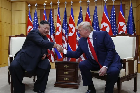 Tổng thống Mỹ Donald Trump (phải) và nhà lãnh đạo Triều Tiên Kim Jong-un trong cuộc gặp ở làng đình chiến Panmunjom tại Khu phi quân sự (DMZ) chiều 30/6/2019. (Ảnh: Yonhap/TTXVN)