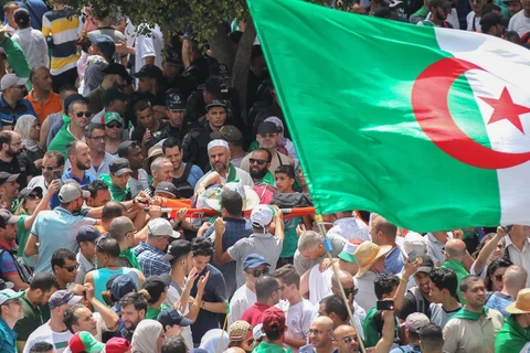 Những người biểu tình mang theo các lá cờ Algeria, đặc biệt là lá cờ khổng lồ ghi tên 48 tỉnh thành nước này, họ vừa hát những bài hát yêu nước để tái khẳng định cam kết không ngừng của họ đối với sự thống nhất, đoàn kết quốc gia và dân tộc. (Ảnh: AFP/TTX