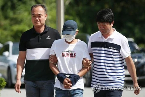 Nghi phạm đánh vợ Việt (giữa) bị áp giải ra tòa án thành phố Gwangju, tỉnh Jeollan Nam hôm 8/7. (Nguồn: Yonhap)