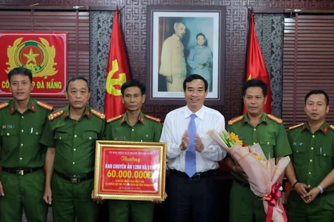 Phó Chủ tịch Ủy ban Nhân dân thành phố Đà Nẵng Lê Trung Chinh trao thưởng cho lực lượng phá án. (Ảnh: Nguyễn Sơn/TTXVN)