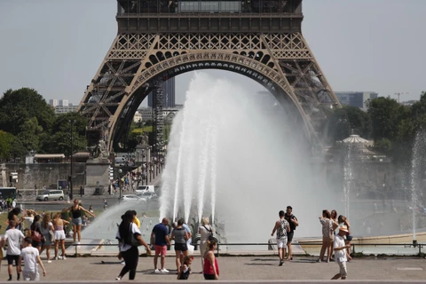 Người dân giải nhiệt tránh nóng tại một đài phun nước ở Paris, Pháp ngày 29/6/2019. (Ảnh: AFP/TTXVN)