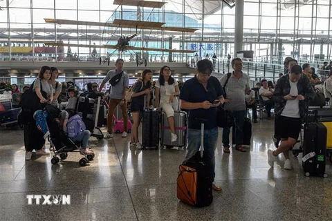 Hành khách tại sân bay quốc tế Hong Kong ngày 14/8. (Ảnh: AFP/TTXVN)