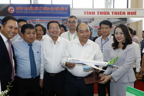 Thủ tướng Nguyễn Xuân Phúc thăm các gian hàng trưng bày tại hội nghị. (Ảnh: Thống Nhất/TTXVN)