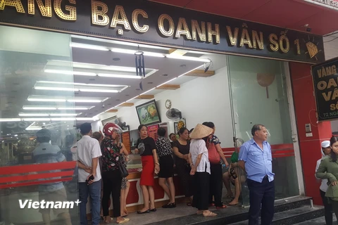 Người dân vây quanh cửa hàng vàng bạc Oanh Vân 1. (Ảnh: Trọng Lịch/Vietnam+)