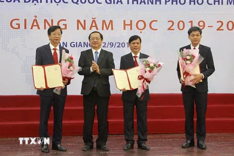 Phó giáo sư Huỳnh Thành Đạt, Giám đốc Đại học Quốc gia thành phố Hồ Chí Minh trao các quyết định bổ nhiệm lại hiệu trưởng, phó hiệu trưởng Trường Đại học An Giang. (Ảnh: Thanh Sang/TTXVN)