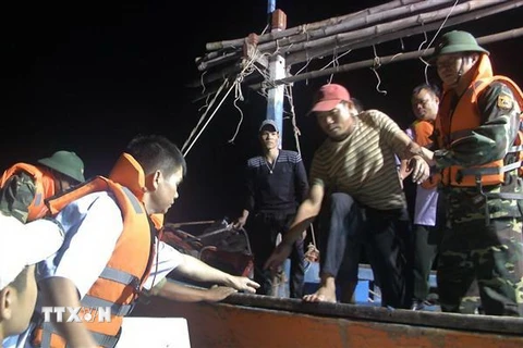 Bộ đội Biên phòng Quảng Bình tiếp nhận 6 ngư dân trên tàu cá gặp nạn. (Ảnh: TTXVN phát)