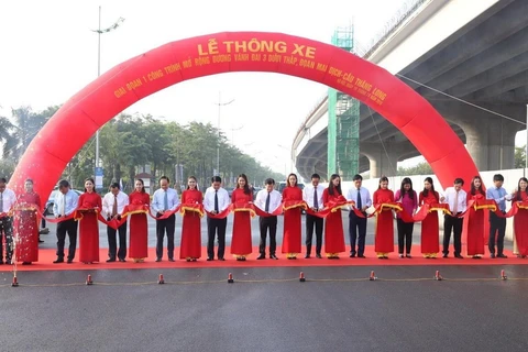 Phó Thủ tướng Trịnh Đình Dũng cùng các đại biểu thực hiện nghi thức cắt băng thông xe. (Ảnh: Dương Giang/TTXVN)