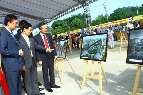 Các đại biểu tham quan Triển lãm ảnh ''Tình hữu nghị đoàn kết đặc biệt Việt Nam-Lào''. (Ảnh: Tá Chuyên/TTXVN)