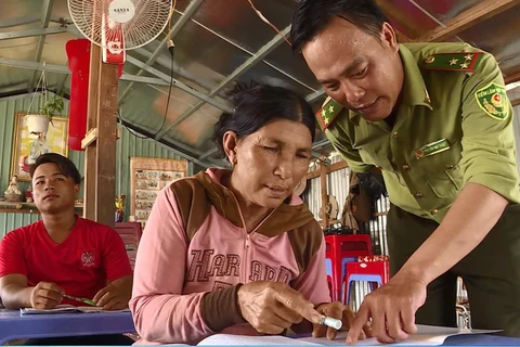 Người dân được chỉ bảo tận tình từng nét chữ trong lớp dạy chữ cho những người Việt kiều Campuchia lớn tuổi trên lòng hồ Trị An. (Ảnh: Lê Xuân/TTXVN)