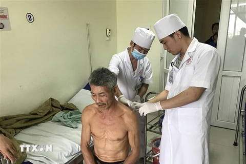 Các bác sỹ bệnh viện Quân y 91 kiểm tra vết thương cho bệnh nhân Ngô Văn Cảnh. (Ảnh: Thu Hằng/TTXVN)