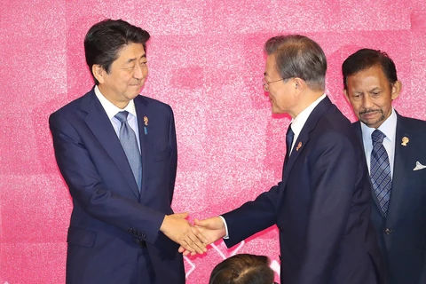 Tổng thống Moon Jae-in (phải) bắt tay Thủ tướng Nhật Bản Abe Shinzo. (Nguồn: Yonhap)