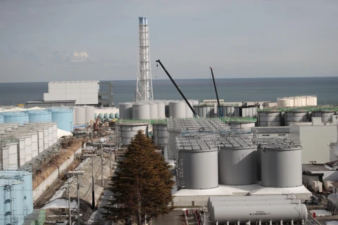 Lò phản ứng số 4 (trái) và các bể chứa nước nhiễm xạ tại nhà máy điện hạt nhân Fukushima Daiichi ở tỉnh Fukushima, Nhật Bản. (Ảnh: AFP/TTXVN)