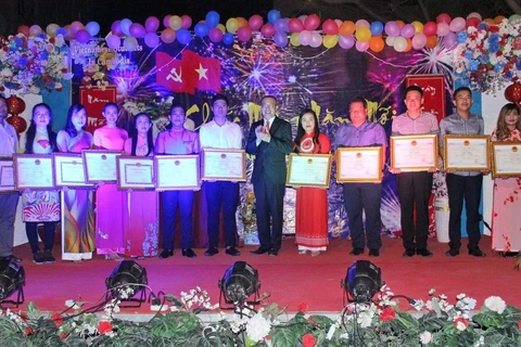 Đại sứ Vũ Quang Minh chụp ảnh lưu niệm với các lưu học sinh có kết quả học tập tốt năm 2019. (Ảnh: Vũ Hùng/TTXVN)